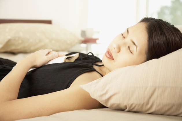 Asian woman sleeping with book