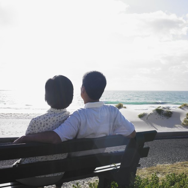 Couple sitting on a bench at the beach