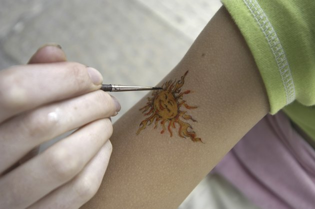 Close-up of a person painting on an arm