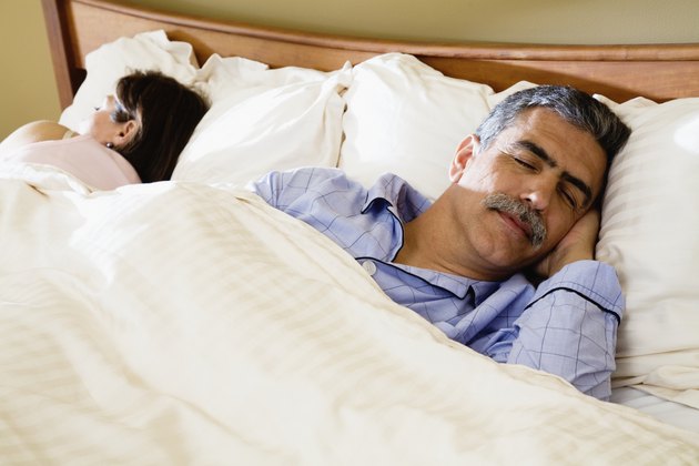 Middle-aged couple sleeping in bed