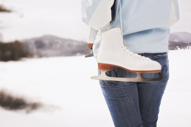 Back view of woman holding ice skates