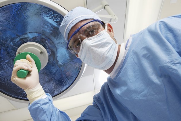 Surgeon adjusting lamp, low angle view