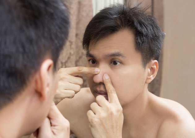 Mirror reflection of asian handsome man viewing his face