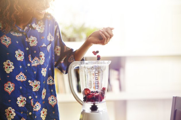 Woman making a smoothie at home.