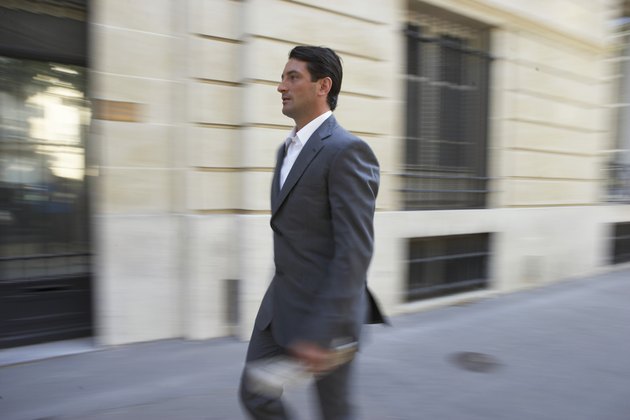 France, Paris, businessman in street (blurred motion)