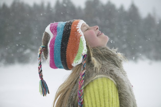 Girl (8-10) on slope, smiling with head back, close-up, side view