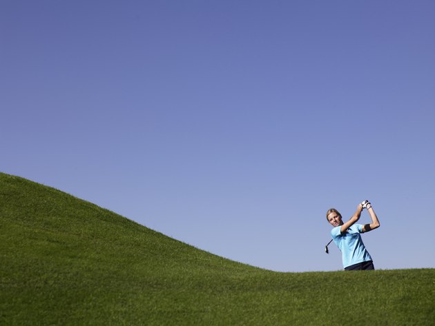 Woman swinging at golf course