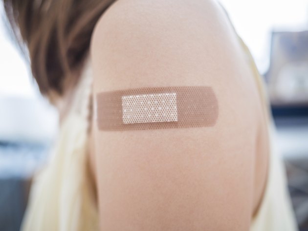 Adhesive bandage on a female arm after vaccination