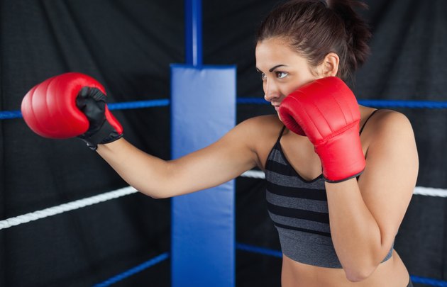 Determined female boxer practicing