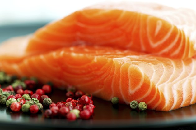 Raw salmon ready to cook close up on black surface