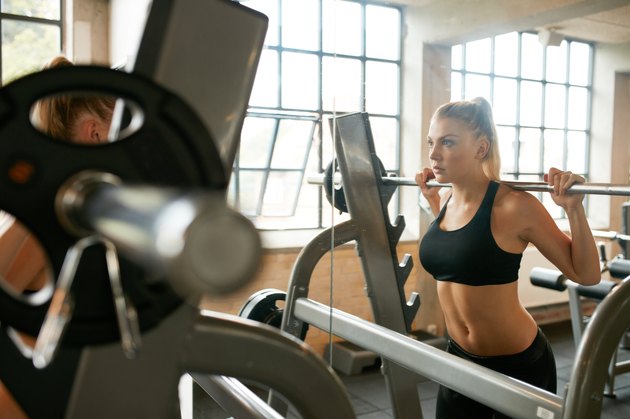 Woman doing squats in gym