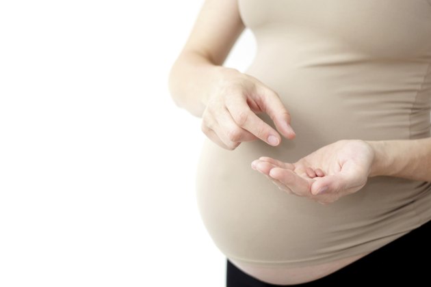 pregnant woman holding pills / vitamins