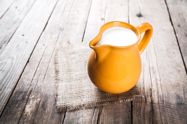 clay milk jug isolated on wooden background