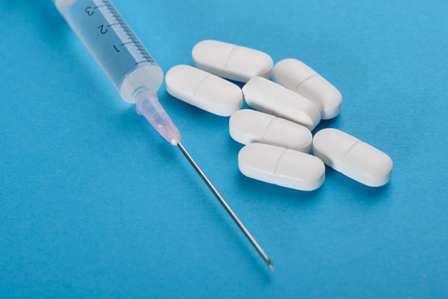 Close-up Of Syringe And Pills