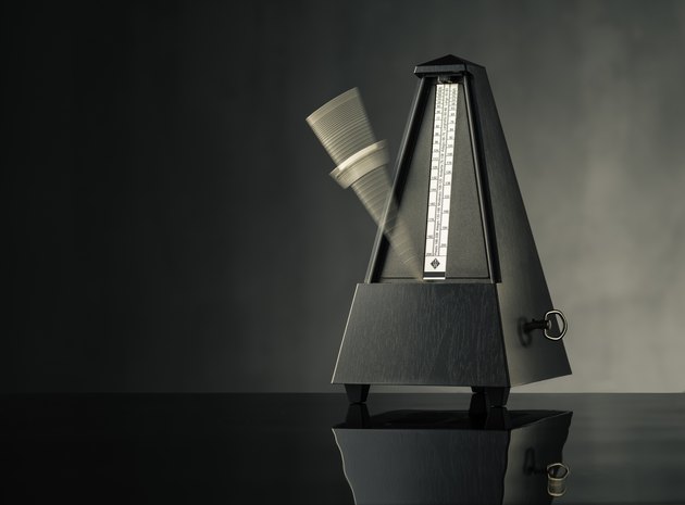 Still life photo of metronome on grey background - horizontal