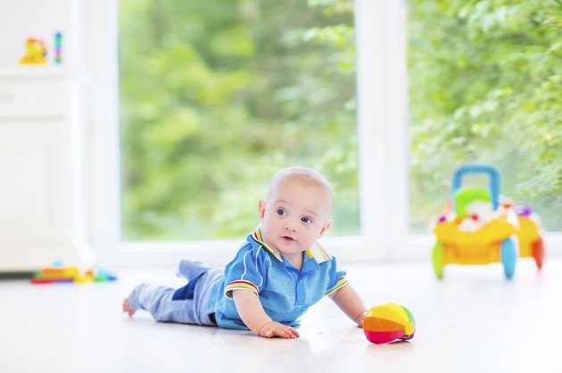 Fanny baby with toy in sunny nursery next big window