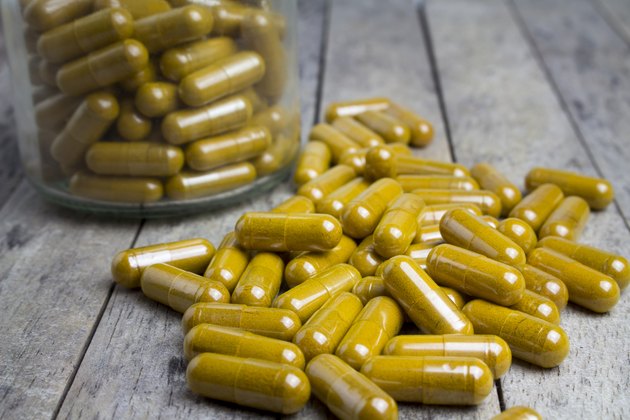 herbal capsules drug on wood board