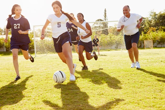 Members Of Female High School Soccer Playing Match