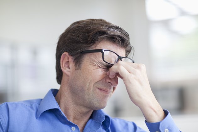 Mature man wincing with a headache