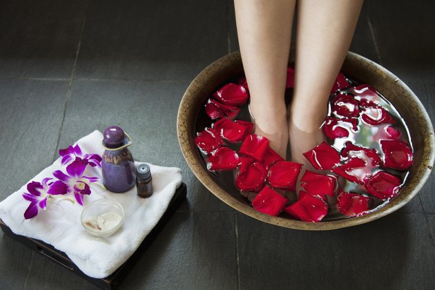 Woman's Feet Soaking in Water with Rose Petals