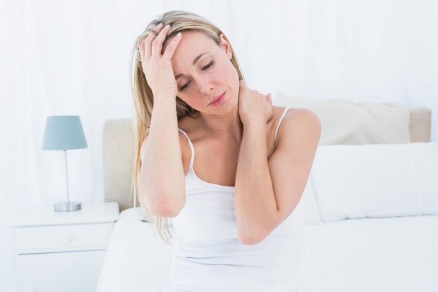 Upset blonde suffering from headache and neck pain