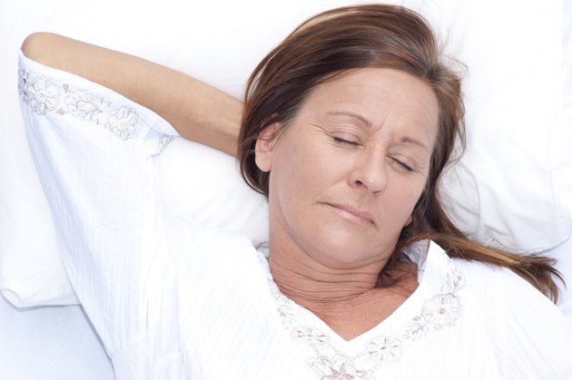 Relaxed mature woman asleep in bed