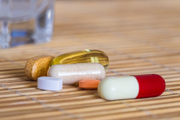 Pills and vitamins plus a glass of water
