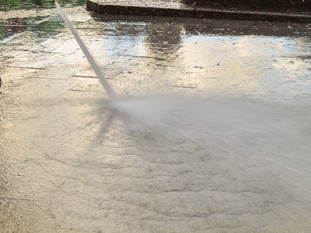 Water under pressure from a cleaning hose