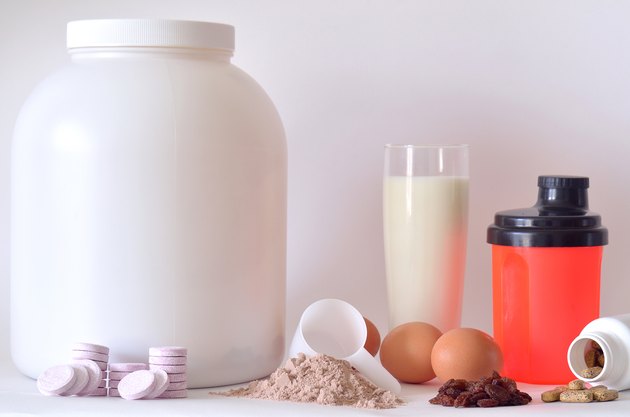 Big jar of protein powder, bottles, shaker, milk, pills
