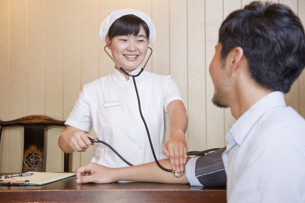 Nurse Checking Businessman's Blood Pressure