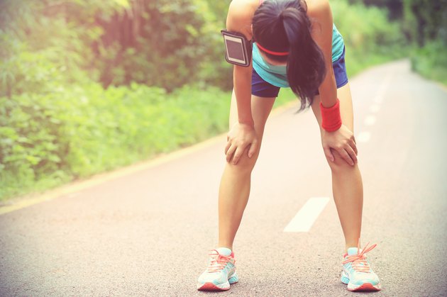 tired woman runner taking a rest after running hard