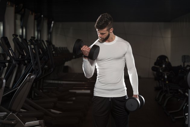 Handsome Man Exercising Biceps With Dumbbells
