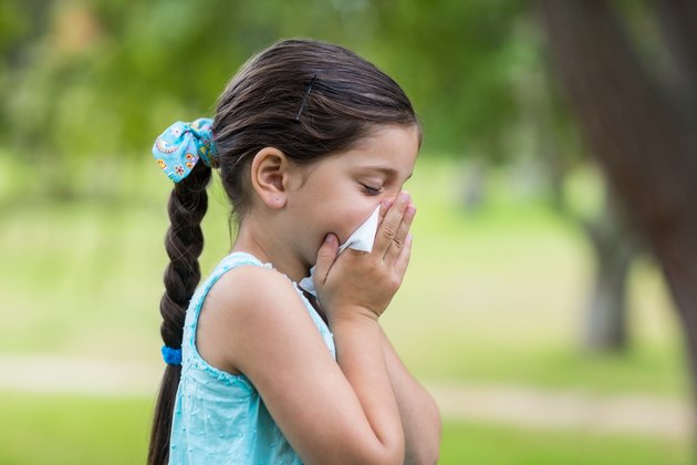 Little girl blowing his nose