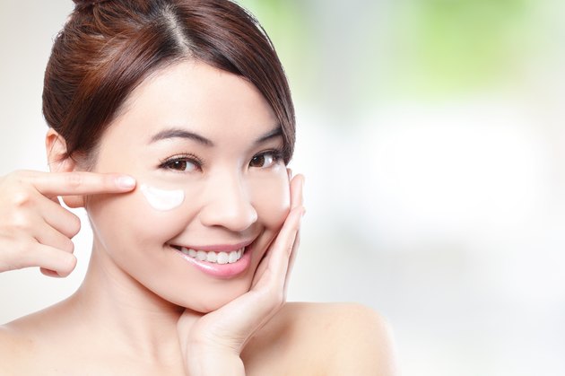 Beauty young woman applying cosmetic cream