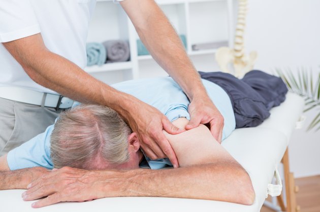 Physiotherapist doing shoulder massage to his patient