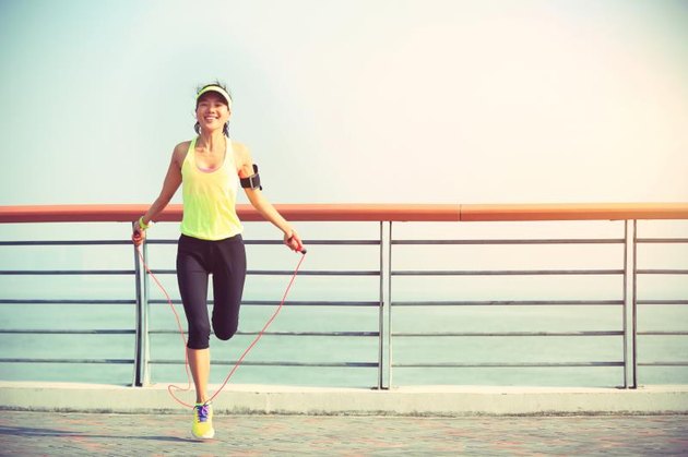 young woman jumping rope at seaside