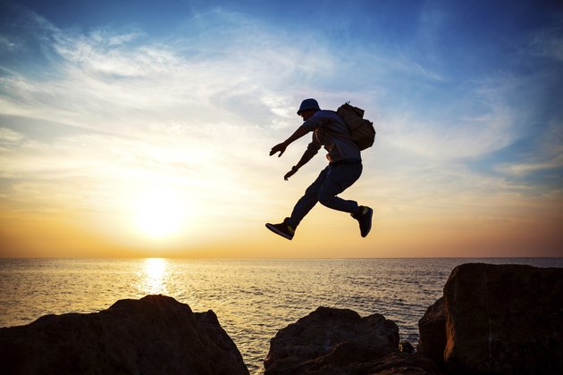 brave man jumping at sunset