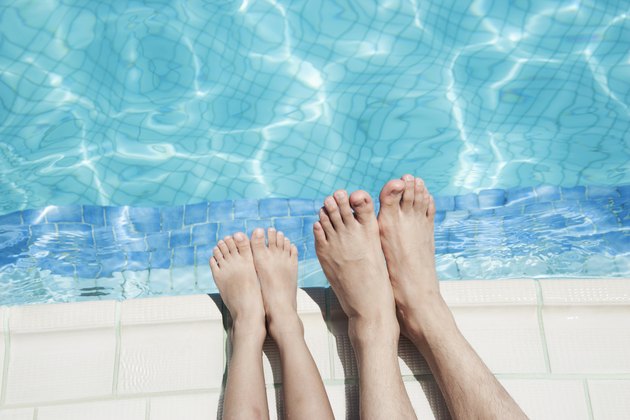 Close up of two people's legs by the pool side