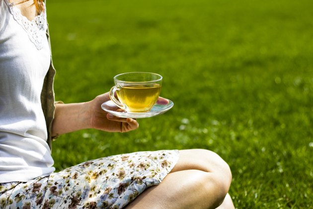 Young woman drinking tea in the park