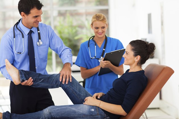 orthopaedist examining female patient's leg