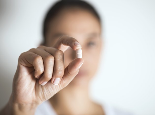 Woman Holding And Showing Medication Capsule