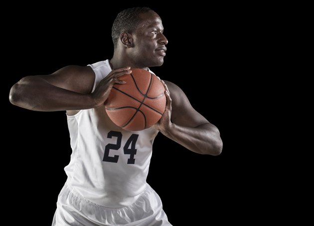 Strong African american basketball player holding the ball