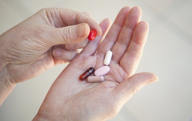 Close up of older person holding pills