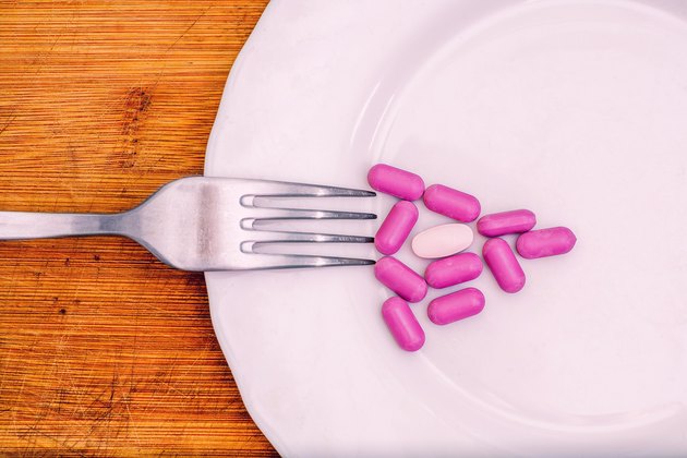 Pink pills in the form of triangle pizza, diet concept