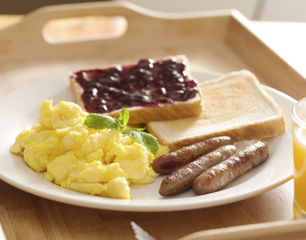 breakfast with scrambled eggs, sausage links and toast.