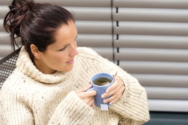 Woman drinking cup tea knitted sweater relaxing