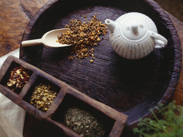 Teapot and peppermint tea lying on wooden tray, (overhead view