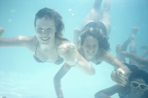 Three young women swimming, underwater view