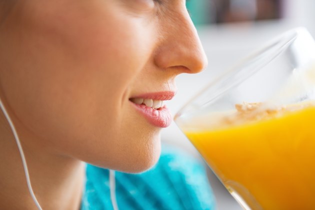 close-up on fitness young woman drinking pumpkin smoothie
