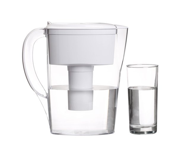 water filter jug with glass of clean water isolated